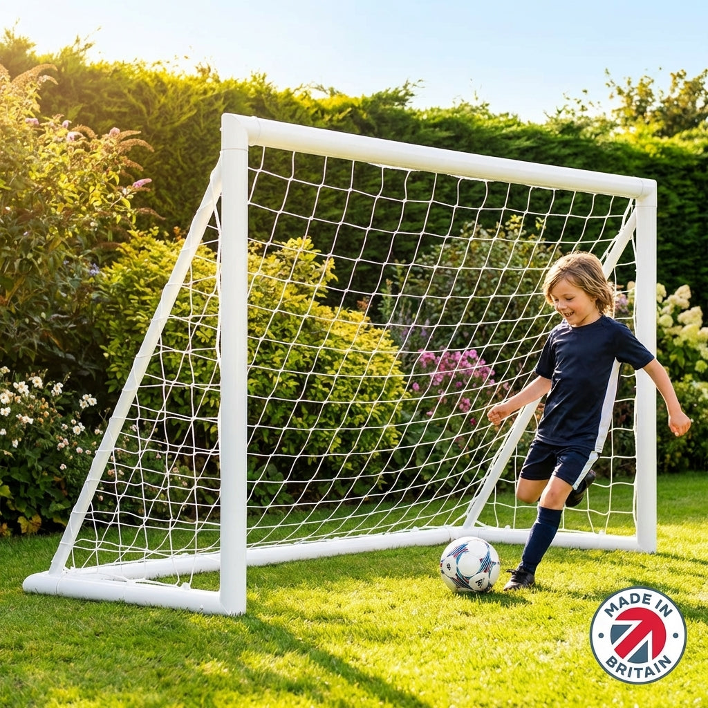 A 6ft by 4ft weatherproof uPVC football goal post for kids, set up on a green lawn in a garden.