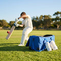 Cricket players set with gloves, pads, abdo guard, and wheelie bag