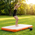 Inflatable gymnastics mat in orange and grey designed for home and gym use